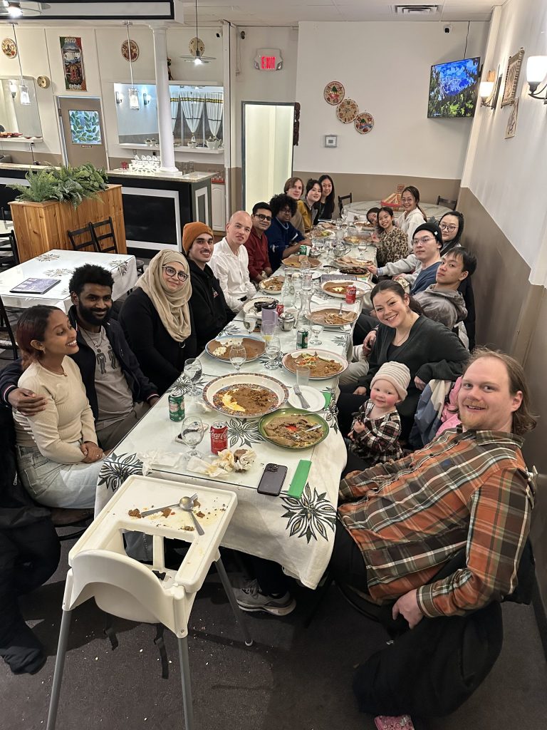 Group members smiling around the long table at the 2024 Christmas dinner