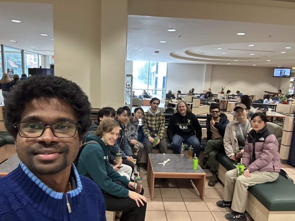 Lab members gathered in a campus lounge, in a selfie taken by one of the group