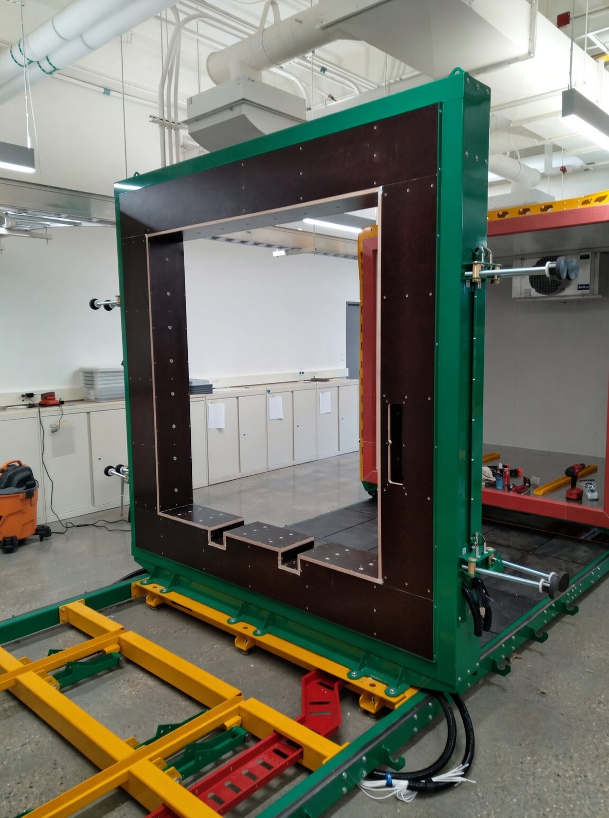 The green thermal test frame in the lab, with the specimen opening framed by its insulated panel.